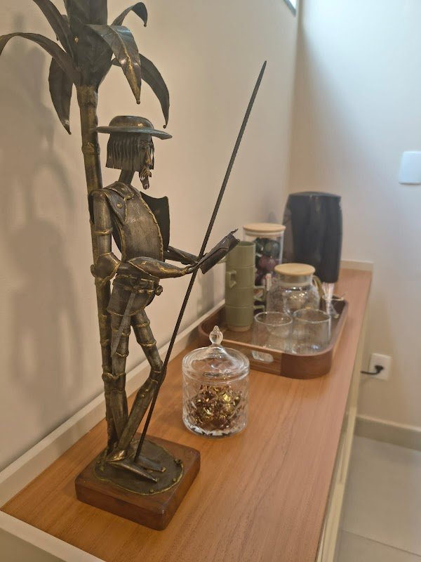 Home Escultura de metal sobre aparador de madeira com bandeja de copos e potes no consultório