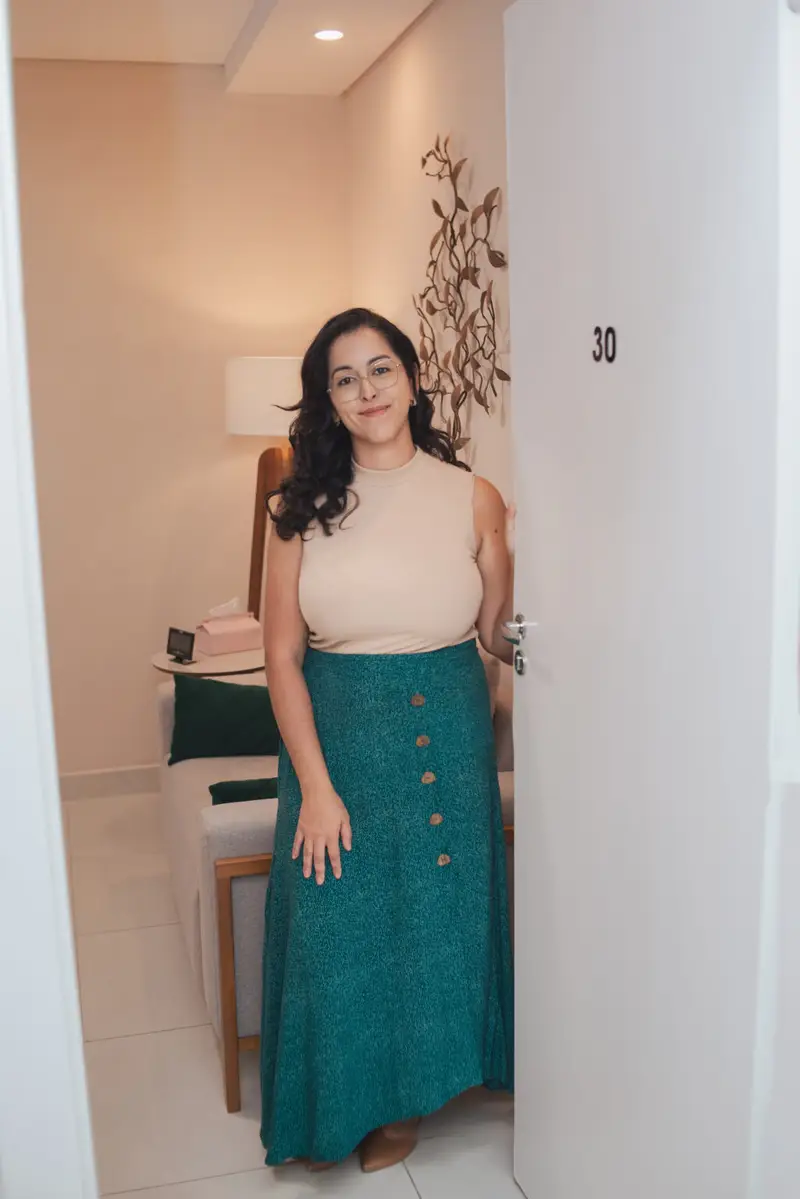 Home Patrícia Melo na porta da sala de atendimento, número 30
